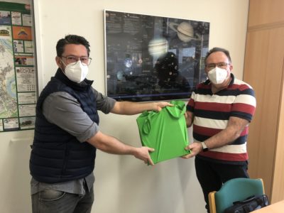 René Jungbluth überreicht Schulleiter Moritz eine Tasche mit Materialien